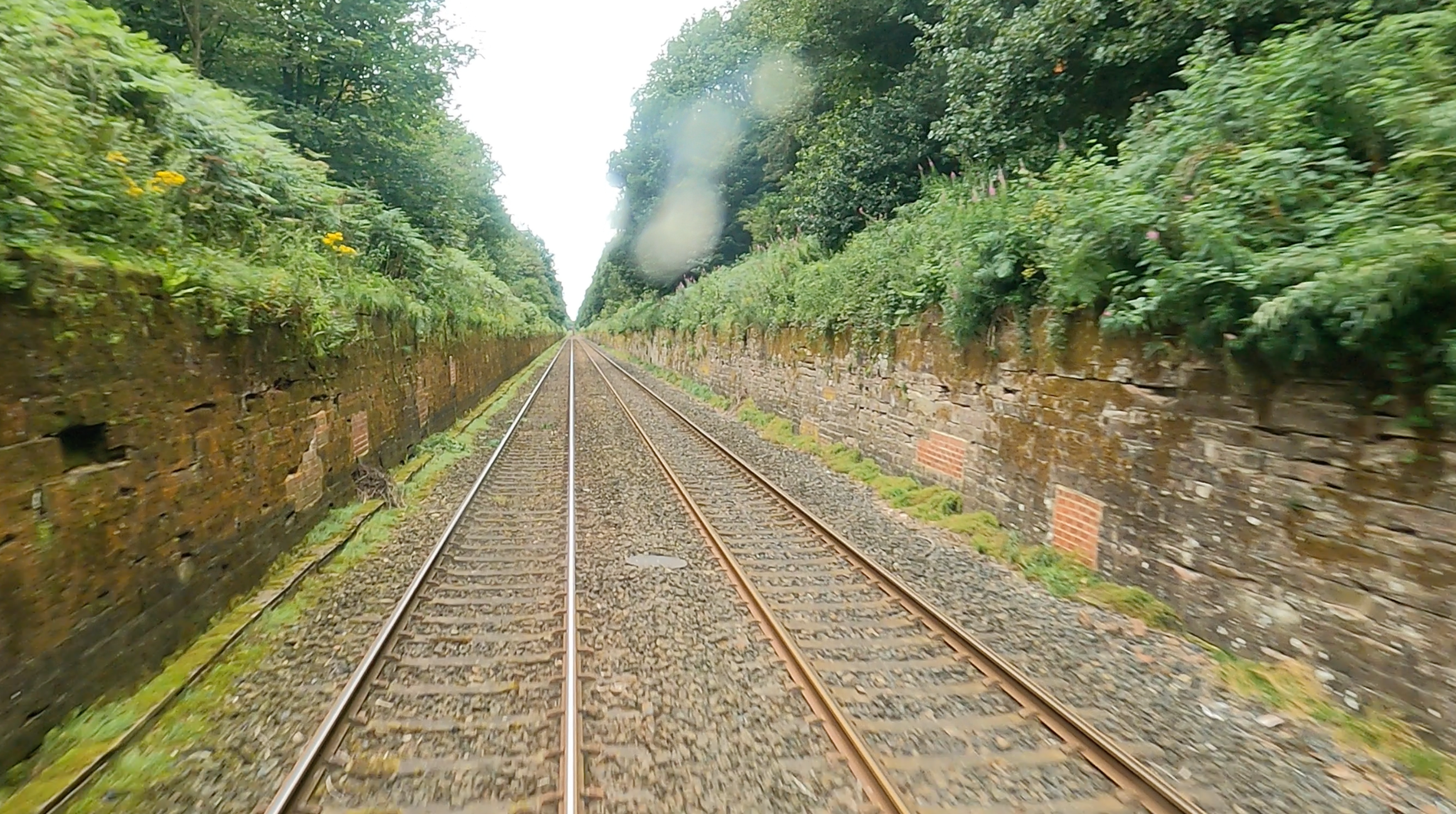 The railway running between the historic stone revetment walls of Cowran Cutting